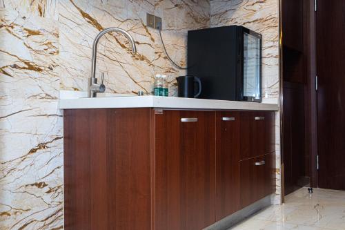 a kitchen with a sink and a marble wall at The Grand View Hotel Changzhou in Changzhou