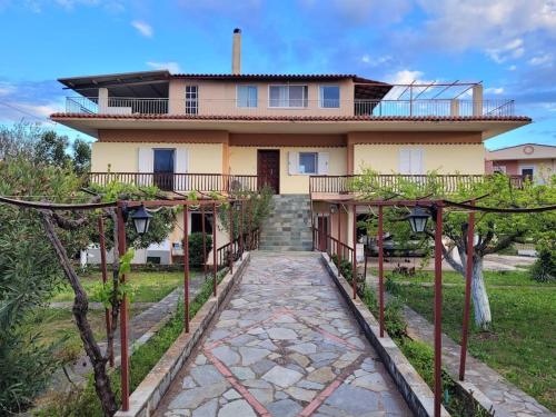 a house with a walkway in front of it at Villa Dimitris near the beach! in Karavómilos