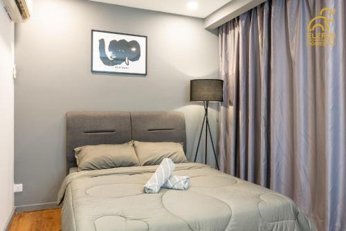 ein Schlafzimmer mit einem Bett, einer Lampe und Vorhängen in der Unterkunft Cosy Unit 5 min walk KL Pavilion KLCC by Elefen Homestay in Kuala Lumpur