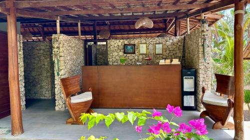 a patio with chairs and a table and some flowers at Jungle Paradise in Nusa Penida