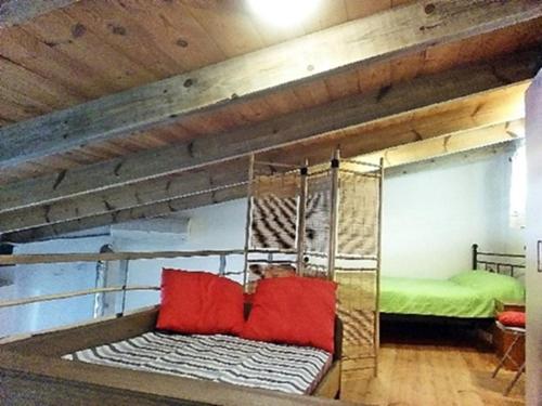 a bunk bed with red pillows in a room at apartment over the sea Private place to swim in Ravdhoúkha