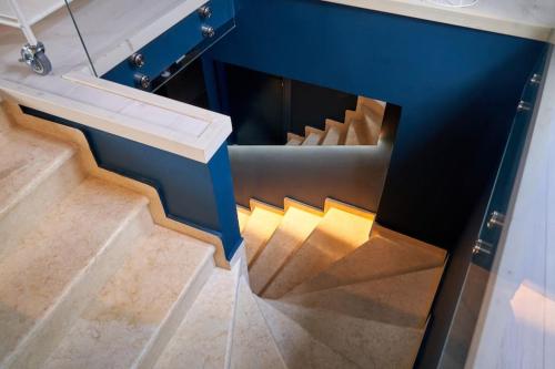 a staircase in a house with blue walls and wooden floors at #SimpliCity Modern Design Studio in Mytilini