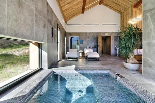 une maison avec une piscine au milieu d'une pièce dans l'établissement Pure Montagne Resort & Spa, à Saint-Martin-Vésubie