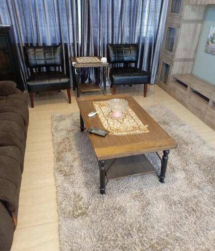 a living room with a coffee table and chairs at Beautiful 1 bedroom rooftop apartment with a great terrace in Rujm ash Sharāʼirah