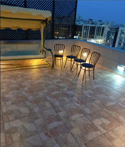 a group of chairs sitting on top of a roof at Beautiful 1 bedroom rooftop apartment with a great terrace in Rujm ash Sharāʼirah