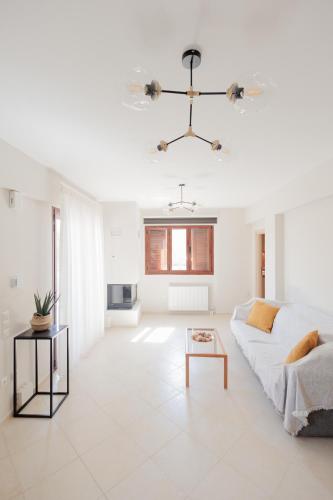 a white living room with a couch and a table at Villa GEM in Porto Rafti