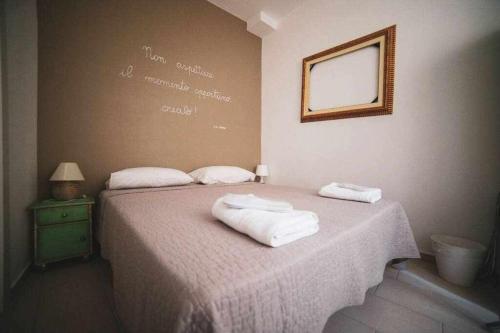 um quarto com uma cama com duas toalhas em LE DIMORE DEGLI ARTISTI Vico Mercatello em Venosa