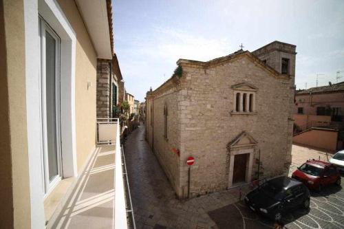an old stone building with cars parked outside a window at LE DIMORE DEGLI ARTISTI Vico Mercatello in Venosa