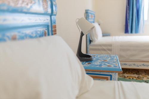 a bedroom with a bed and a lamp on a table at Casa Voyager 'secret garden terrace' in Chefchaouene