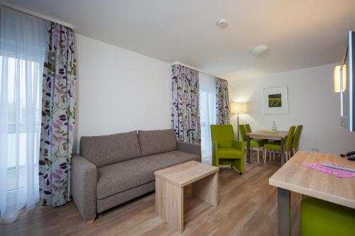 ein Wohnzimmer mit einem Sofa und einem Tisch in der Unterkunft Hotel Am Pan in Emmerich