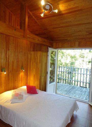 une chambre avec un lit et une grande fenêtre dans l'établissement Les Chalets Cobadena-Borda Pays Basque, à Mouguerre