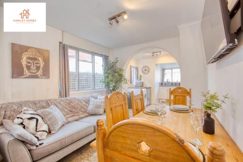 ein Wohnzimmer mit einem Sofa und einem Tisch in der Unterkunft Bridgwater Bliss: 6-Bedroom Haven for Large Groups in Bridgwater