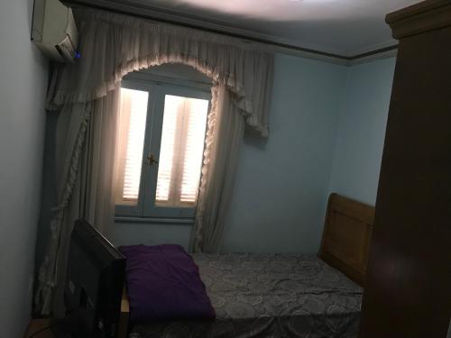 a bedroom with a bed and a window at In ibrahimia midtown Alex in Alexandria