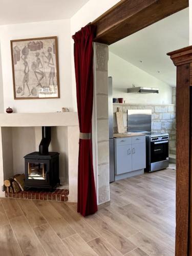 un salon avec cheminée et une cuisine dans l'établissement Chez Juliette - Maison et jardin - bord de Loire à Saumur, à Saumur