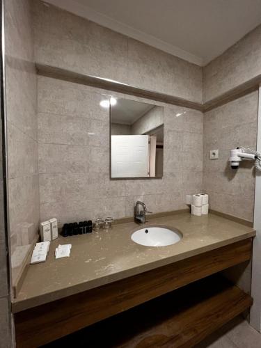 a bathroom with a sink and a mirror at Maya World Didyma Hotel in Didim