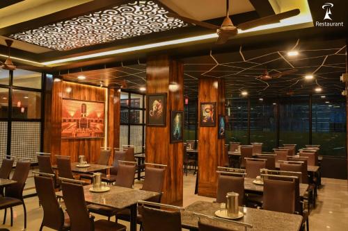 a restaurant with tables and chairs in a room at Ramana Towers in Tiruvannāmalai