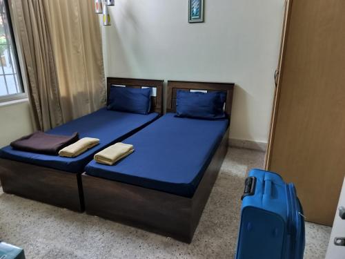 a bedroom with a bed with blue sheets and blue pillows at A & P Apartments in Thane