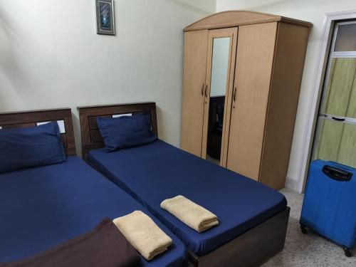 a bedroom with two beds and a cabinet at A & P Apartments in Thane