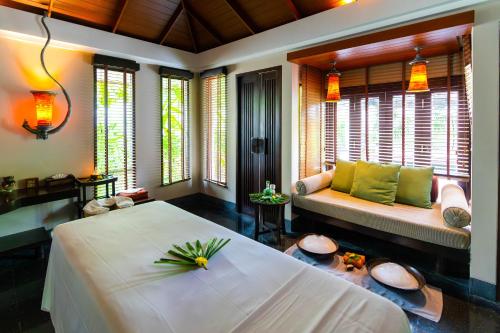 a bedroom with a bed and a couch and windows at Paradox Resort Phuket in Karon Beach