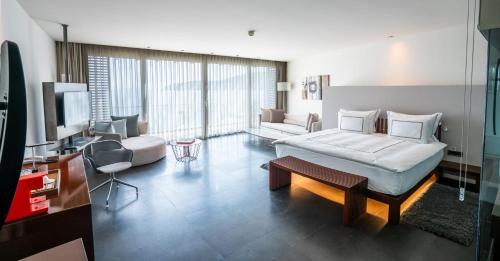 a bedroom with a bed and a couch and a tv at Kuum Hotel & Spa in Golturkbuku