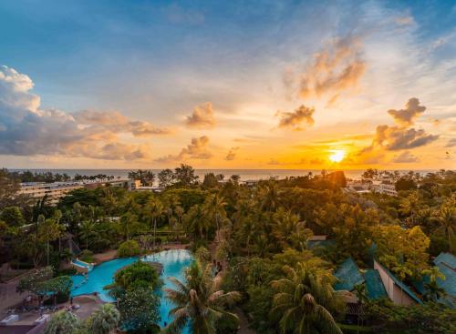 an aerial view of a resort with a pool and the ocean at Paradox Resort Phuket in Karon Beach