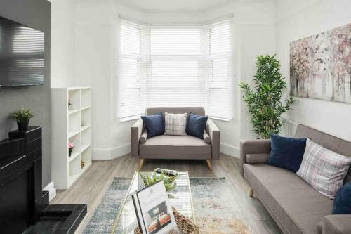 a living room with a couch and a table at Pleasant 4 bed house with x6 beds in heart of Croydon !! - Photo ID Required in Croydon