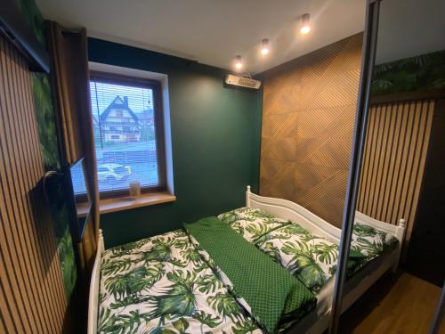 a small bedroom with a bed and a window at Apartament Zielona Przystań Kluszkowce - 1 km od VELO CZORSZTYN I CZORSZTYNSKI!!! in Kluszkowce