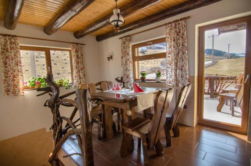 een eetkamer met een houten tafel en stoelen bij Casa Bălan in Fundăţica