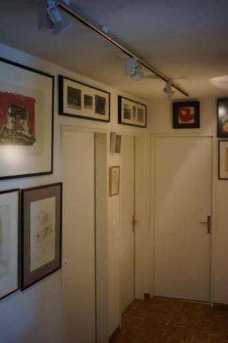 a hallway with pictures on the walls and a door at GFM in Zurich