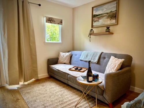 a living room with a couch and a table at Highland HotTub Retreat, on NC500 in Inverness