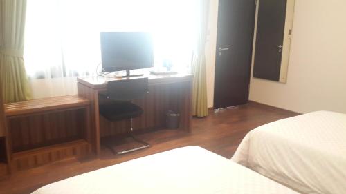 a bedroom with a desk with a television on it at Dago Teuku Angkasa 14 in Bandung