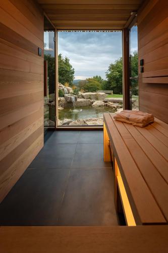 a room with a bench and a large window at Hortus Vita Wellness Apartments in Lipnice nad Sázavou