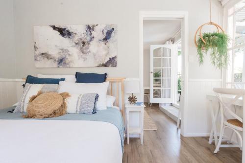 a bedroom with a bed and a painting on the wall at Studio 26: Central, Hampton’s Poolside Hideaway in Coffs Harbour