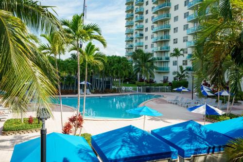 a swimming pool with blue umbrellas and a building at OCEAN RESERVE 15th Floor - Gorgeous Ocean View - STR00907 in Miami Beach