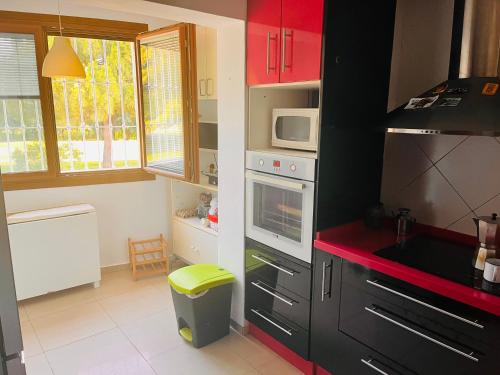 une cuisine avec des armoires noires et un comptoir rouge dans l'établissement Apartamento de la Cruz, à Mérida