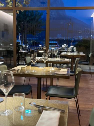 a restaurant with tables and chairs with wine glasses at Hotel Promessi Sposi in Malgrate