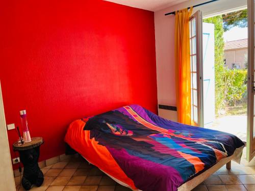 ein Schlafzimmer mit einer roten Wand und einem Bett in der Unterkunft Beautiful house garden-floor with sea view & 10 min walk in Vallauris