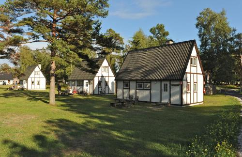 a group of white houses on a grass field at Sudersand Resort in Fårö