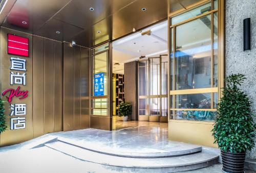 un vestíbulo de un edificio con una maceta en 宜尚Plus酒店广州北京路步行街店, en Guangzhou