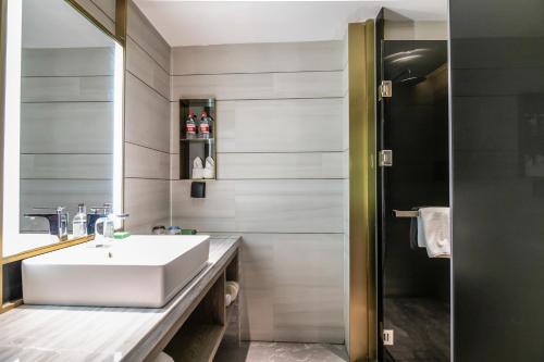 a bathroom with a white sink and a shower at Echarm PLUS Hotel Guangzhou Beijing Road Pedestrian Street Dafo Ancient Temple in Guangzhou