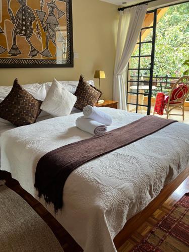 una camera da letto con un grande letto con una grande finestra di Hob House a Nairobi
