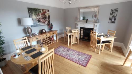 a living room with a table and chairs and a fireplace at Plas Tan y Graig B&B Guest House Beddgelert in Beddgelert