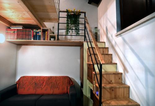um quarto com uma escada com um sofá e uma prateleira em LA CASA SUL LARA em Santo Stefano di Rogliano