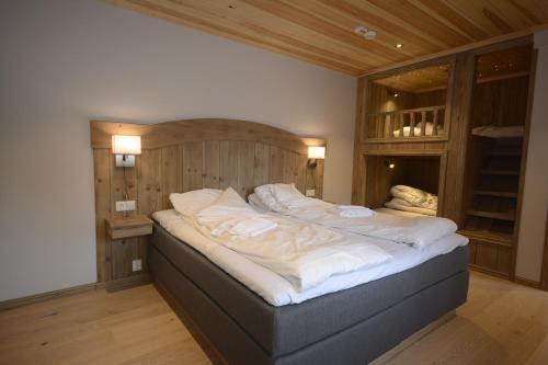 um quarto com uma cama grande e lençóis brancos em HERMON HØYFJELLSSENTER em Skoro