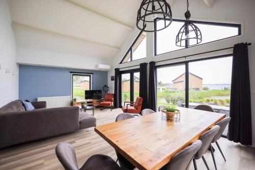 a living room with a wooden table and chairs at Strandparc Nulde in Putten