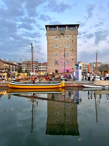 a boat in the water in front of a building at Hotel Smart Cervia B&B in Cervia