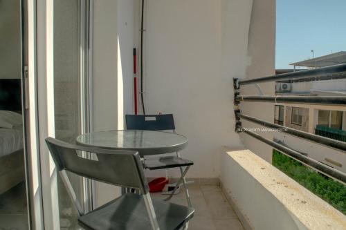 ein Tisch und ein Stuhl in einem Zimmer mit Fenster in der Unterkunft Mad beach in Protaras