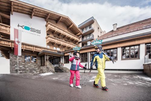 two people are standing in front of a building at KOSIS Sports Lifestyle Hotel in Fügen
