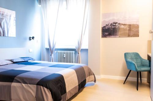 a bedroom with a bed and a chair and a window at Arò Design Suite in Asti