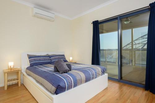 a bedroom with a bed and a large window at 120 Madaffari Drive in Exmouth